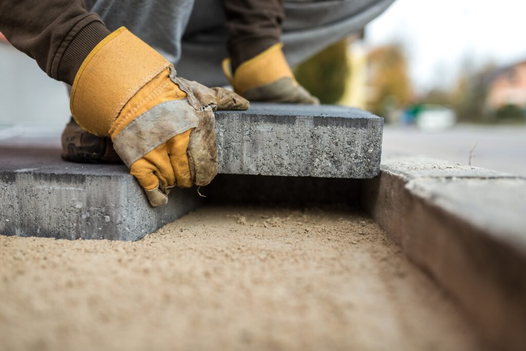 Workman laying exterior paving stones